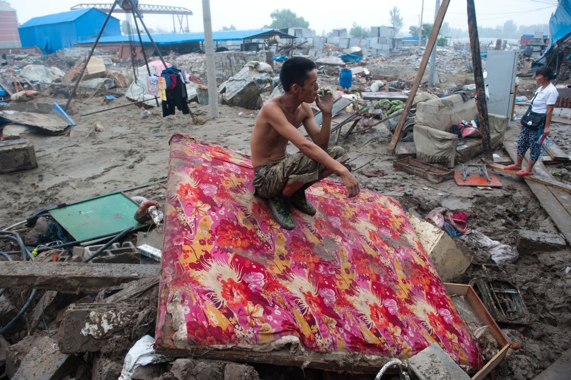 A man rests by his destroyed home in the devasted area of Beijing in July 2012, after severe flooding.