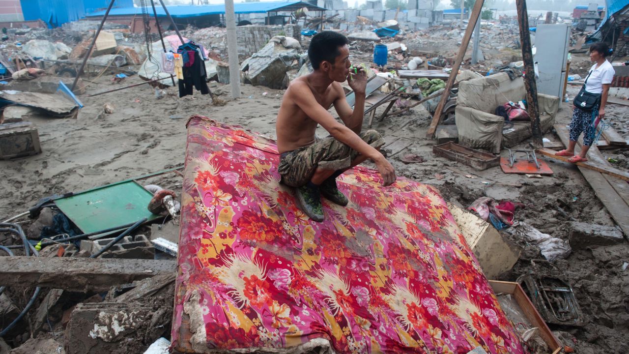 A man rests by his destroyed home in the devasted area of Beijing in July 2012, after severe flooding.
