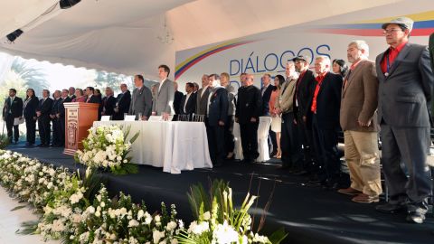 Representatives from the Colombian government and the ELN stand before the start of peace talks in Ecuador on February 7, 2017.