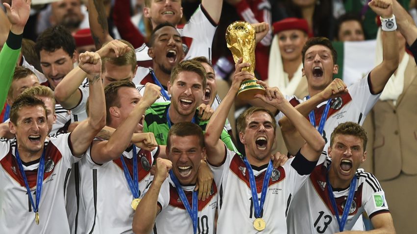 Germany's defender and captain Philipp Lahm (front-R) holds up the World Cup trophy as he celebrates on with his teammates after winning the 2014 FIFA World Cup final football match between Germany and Argentina 1-0 following extra-time at the Maracana Stadium in Rio de Janeiro, Brazil, on July 13, 2014.  AFP PHOTO / FABRICE COFFRINI        (Photo credit should read FABRICE COFFRINI/AFP/Getty Images)
