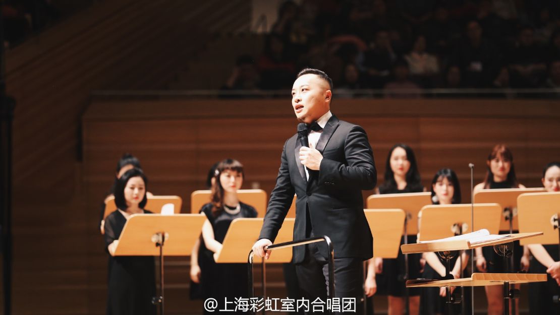 Jin Chengzhi speaks to the audience at the choir's Spring Festival concert.