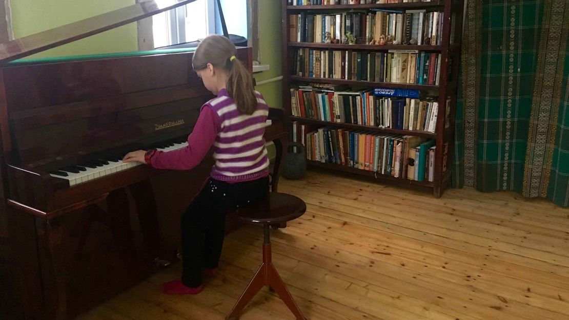 Mariika Savkevich plays the piano at her home in Avdiivka, while Ukraine's war rages nearby.