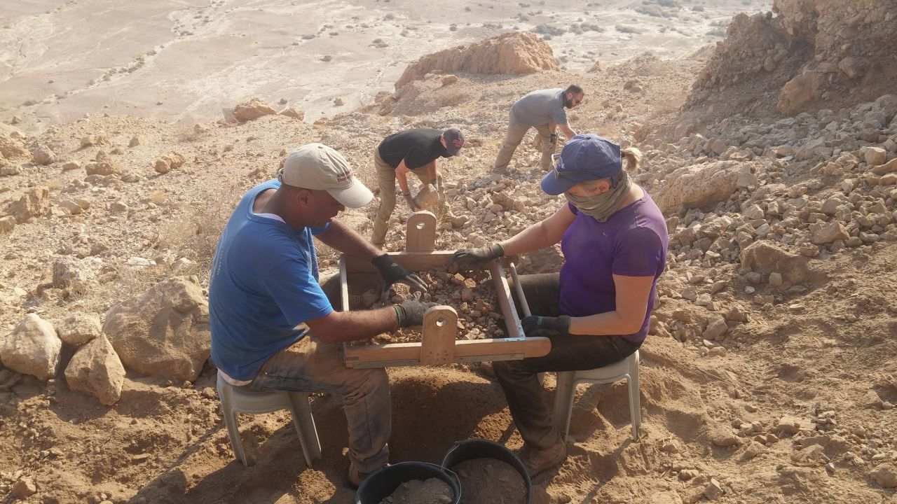 The team sifts through material near the newly discovered cave.