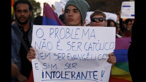 A protester against homophobia at a march in Brasilia, Brazil holds a sign that reads: "The problem is not being Catholic or being Evangelical, but being intolerant."