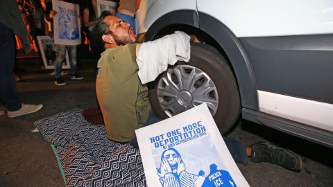 A protester locks himself to the van carrying Garcia de Rayos away.