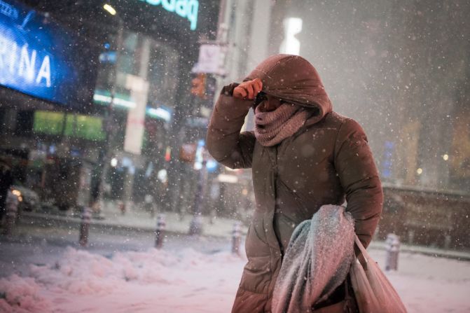 A woman braces against the wind-blown snow in Times Square.