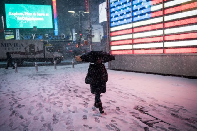 A woman walks through Times Square.