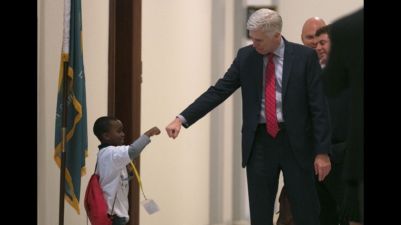 Supreme Court nominee Neil Gorsuch fist-bumps Charles Marshall III as he arrives for a meeting in Washington on Wednesday, February 8. Gorsuch has been visiting with US senators from both parties.