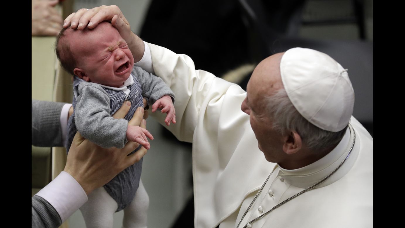 Pope Francis touches a crying baby at the Vatican on Saturday, February 4.