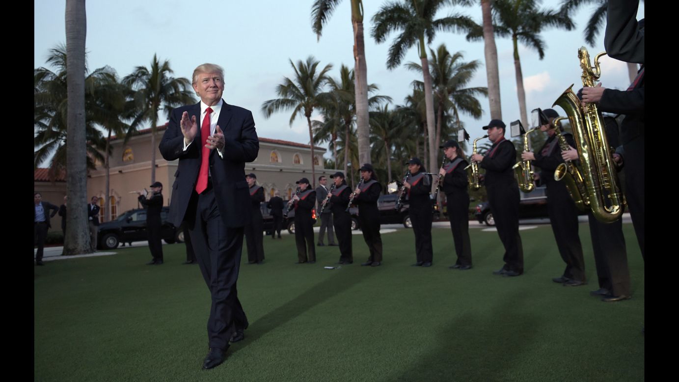 US President Donald Trump listens to a high school marching band as he arrives at the Trump International Golf Club in West Palm Beach, Florida, on Sunday, February 5.