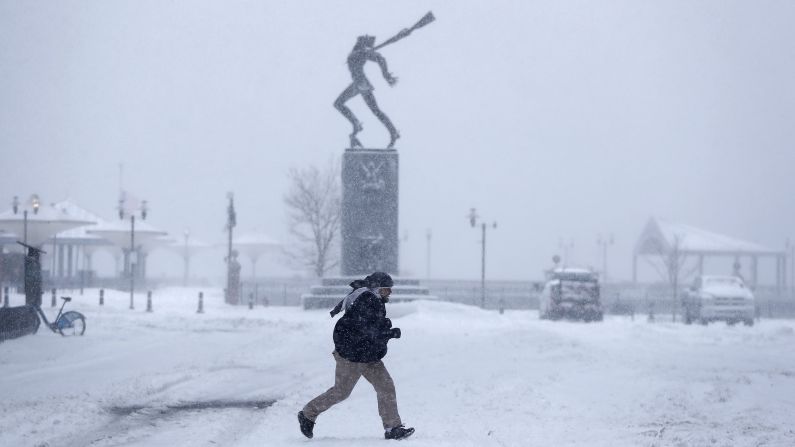 A person runs across a snow-covered area in Jersey City, New Jersey, on February 9.