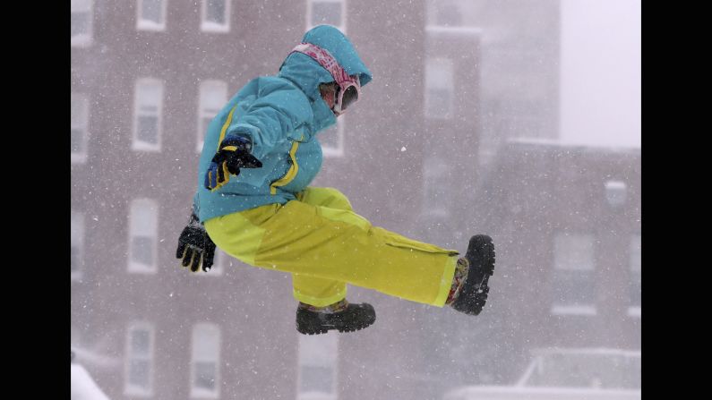 Carina Stack jumps from a snowbank while playing in Portland, Maine, on February 9.