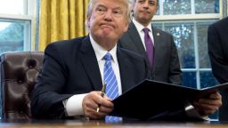 TOPSHOT - US President Donald Trump signs an executive order as Chief of Staff Reince Priebus looks on in the Oval Office of the White House in Washington, DC, January 23, 2017.
Trump on Monday signed three orders on withdrawing the US from the Trans-Pacific Partnership trade deal, freezing the hiring of federal workers and hitting foreign NGOs that help with abortion. / AFP / SAUL LOEB        (Photo credit should read SAUL LOEB/AFP/Getty Images)