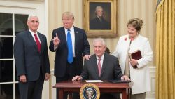 WASHINGTON, DC - FEBRUARY 1:  (AFP OUT) U.S. President Donald Trump (2nd L) reacts after  Rex Tillerson (seated), accompanied by wife Renda St. Clair, signed an appointment affidavit after being sworn in as the 69th secretary of state by Vice President Mike Pence (L) in the Oval Office of the White House on February 1, 2017 in Washington, DC. Tillerson was confirmed by the Senate earlier in the day in a 56-43 vote.  (Photo by Michael Reynolds-Pool/Getty Images)