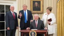 WASHINGTON, DC - FEBRUARY 1:  (AFP OUT) U.S. President Donald Trump (2nd L) reacts after  Rex Tillerson (seated), accompanied by wife Renda St. Clair, signed an appointment affidavit after being sworn in as the 69th secretary of state by Vice President Mike Pence (L) in the Oval Office of the White House on February 1, 2017 in Washington, DC. Tillerson was confirmed by the Senate earlier in the day in a 56-43 vote.  (Photo by Michael Reynolds-Pool/Getty Images)