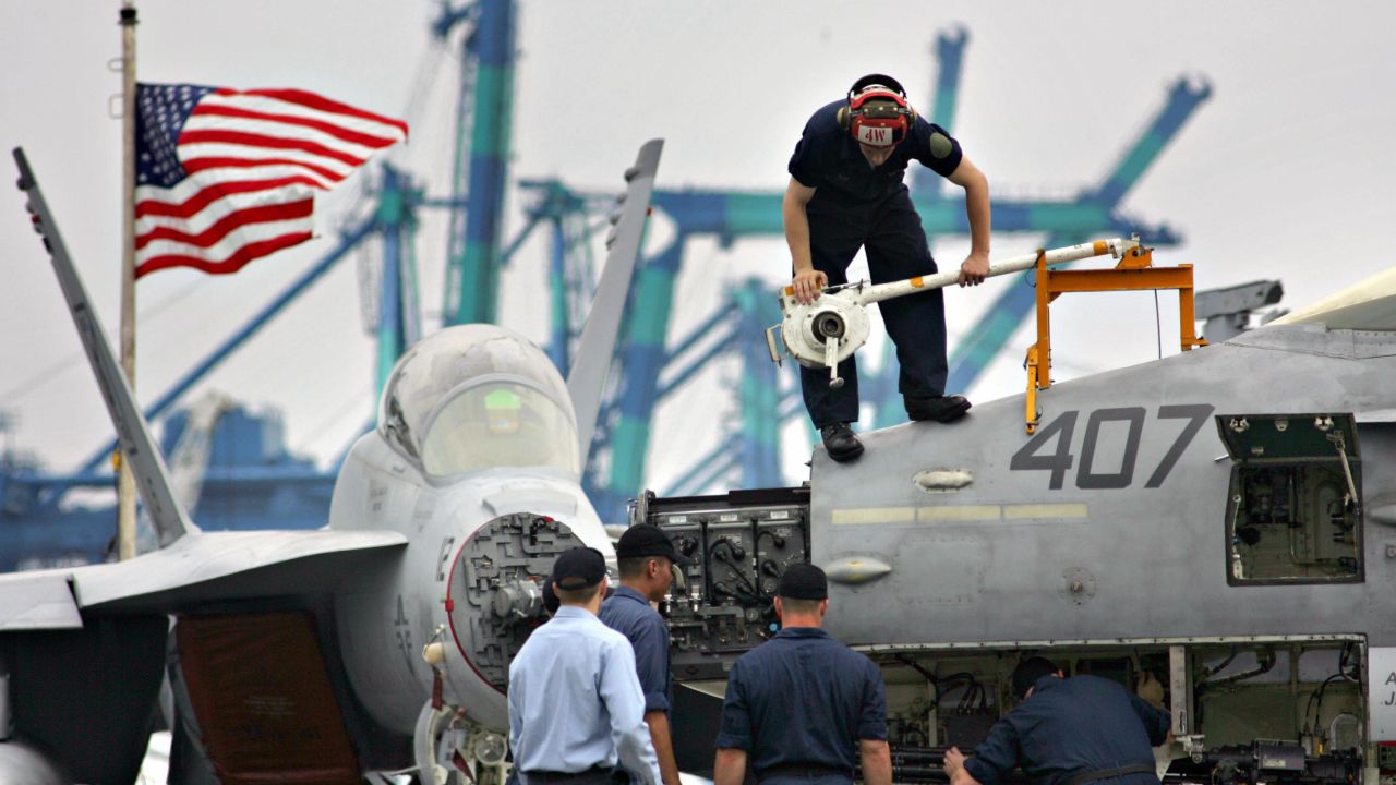 PORT KLANG, MALAYSIA:  US Navy maintenance crew work on the radome of an F/A-18 Hornet strike aircraft on board the US aircraft carrier Nimitz in Port Klang, 30 June 2005. The USS Nimitz, the world's largest nuclear-powered aircraft carrier with a length of nearly 1,100 feet (340m) and a displacement over 95,000 tons, is in Malaysia for a scheduled port call until 04 July 2005. AFP PHOTO/TENGKU BAHAR  (Photo credit should read TENGKU BAHAR/AFP/Getty Images)