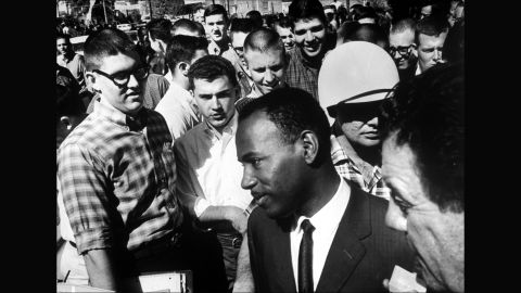 James Meredith is accompanied by two federal marshals and surrounded by jeering students after registering for entry at the <strong>University of Mississipp</strong>i in the fall of 1962. The first African-American student to enroll at the school, Meredith suffered constant harassment on campus before graduating the next year.