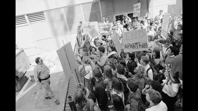 A group of anti-apartheid demonstrators find themselves blocked off behind the municipal building in Berkeley, California on April 18, 1985, after marching from campus to a courthouse where 20 demonstrators were awaiting arraignment. The protesters became trapped in an alley after police closed a gate on them. 