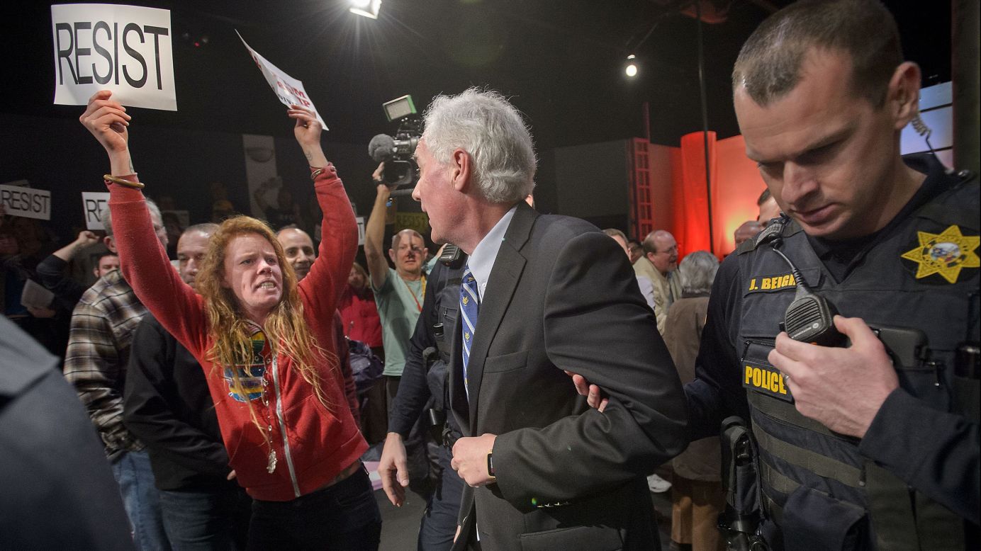 Police in Roseville, California, escort Republican congressman Tom McClintock past protesters during a town hall meeting at the city's Tower Theatre on Saturday, February 4. Some protesters, upset with McClintock's support for President Trump's agenda, followed him, shouting, "Shame on you!" 