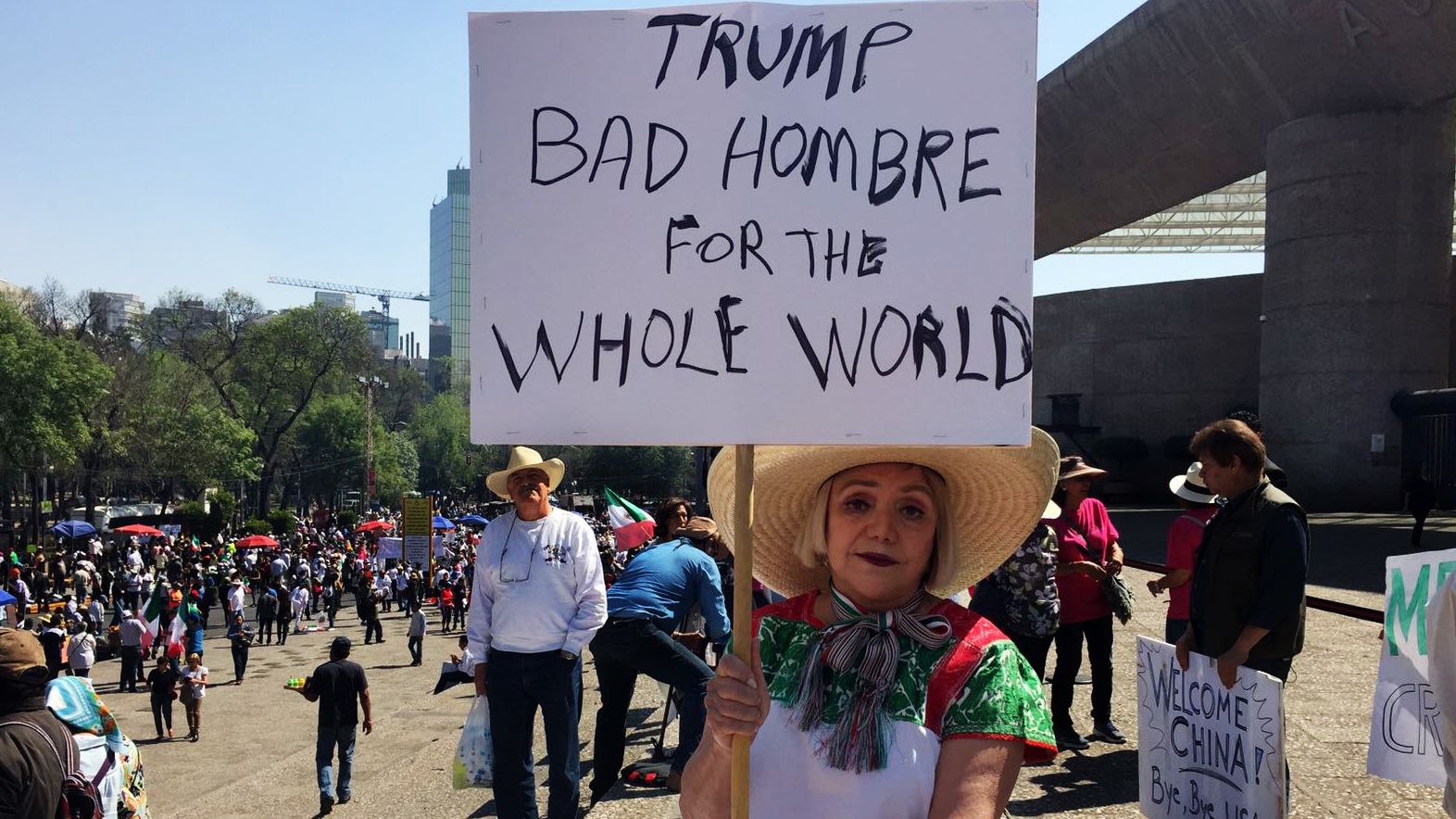 Maria Eugenia Montes de Oca holds up a sign lambasting Trump as a 