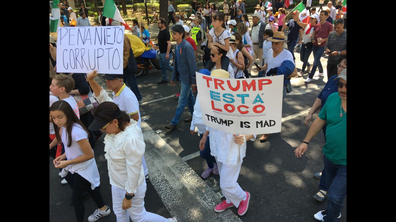 Protesters hold signs that read "Peña Nieto is corrupt" and "Trump is crazy."