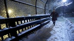 A person walks on a snow-covered sidewalk on a bridge near a commuter rail station Sunday, Feb. 12, 2017, in Wellesley, Mass. Another winter blast of snow and strong winds moved into the Northeast on Sunday to the delight of some and the consternation of others, just days after the biggest storm of the season dumped up to 19 inches of snow in the region. (AP Photo/Steven Senne)