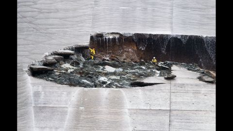 Workers inspect a hole that developed in the main spillway on Wednesday, February 8.