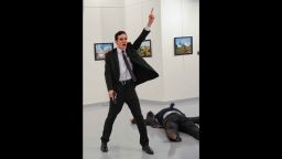 FILE - In this Monday, Dec. 19, 2016 file photo, Mevlut Mert Altintas shouts after shooting Andrei Karlov, right, the Russian ambassador to Turkey, at an art gallery in Ankara, Turkey. At first, AP photographer Burhan Ozbilici thought it was a theatrical stunt when a man in a dark suit and tie pulled out a gun during the photography exhibition. The man then opened fire, killing Karlov. (AP Photo/Burhan Ozbilici)