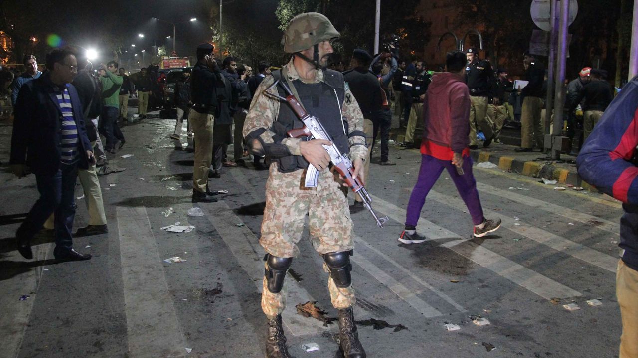 Police and security officers cordon off the area of a deadly bombing, in Lahore, Pakistan, on Monday.