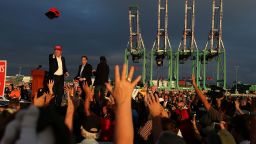 Republican presidential candidate Donald Trump throws a hat to supporters during a campaign rally aboard the USS Iowa on September 15, 2015, in Los Angeles.