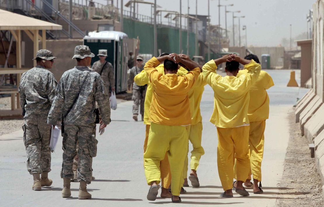 Iraqi prisoners are escorted by US soldiers within US-run detention centre, Camp Cropper, on the outskirts of Baghdad on June 23, 2009. 