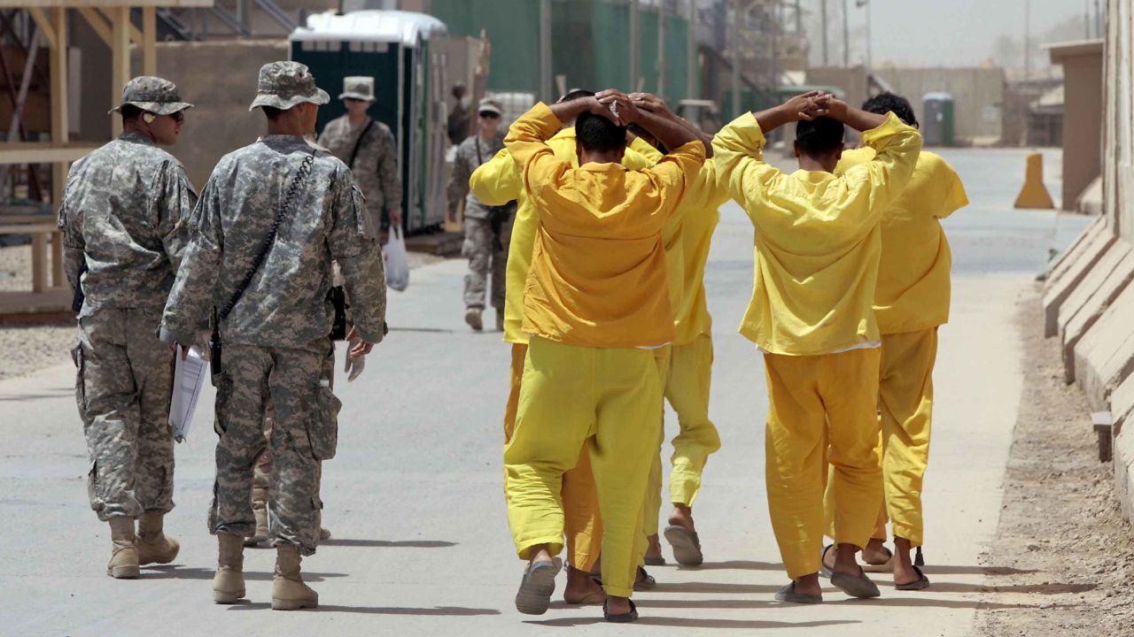 Iraqi prisoners are escorted by US soldiers within US-run detention centre, Camp Cropper, on the outskirts of Baghdad on June 23, 2009.
