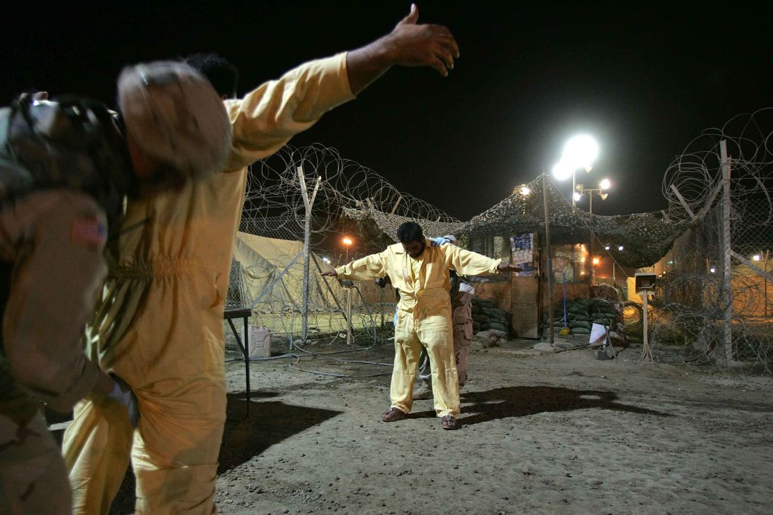 US military pat down suspected insurgents while processing new detainees at the Abu Ghraib Prison October 27, 2005 in Baghdad, Iraq. 