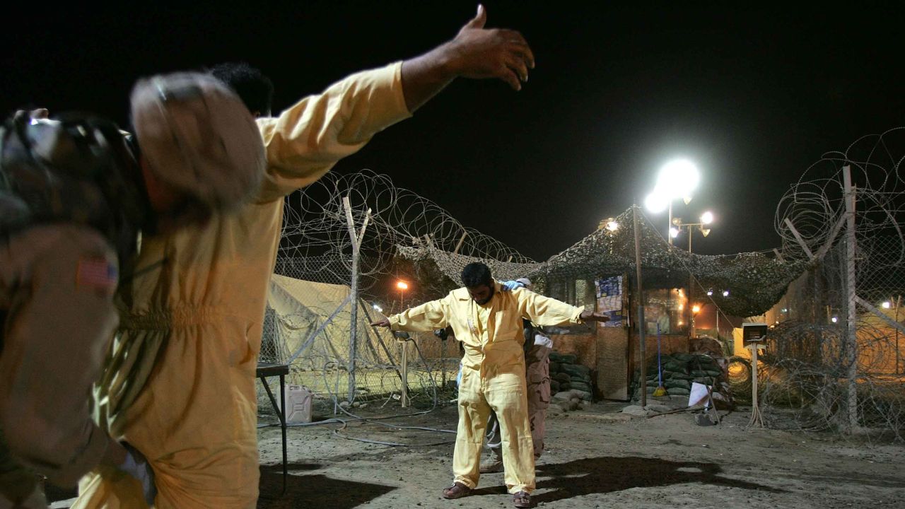 US military pat down suspected insurgents while processing new detainees at the Abu Ghraib Prison October 27, 2005 in Baghdad, Iraq.