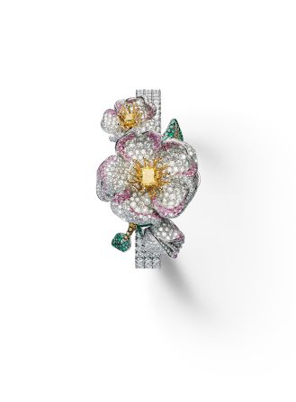 The diamond-set dial on this white and yellow gold watch is hidden beneath an elaborate flower adorned with white, yellow, cognac and gray diamonds, pink sapphires and emeralds. 