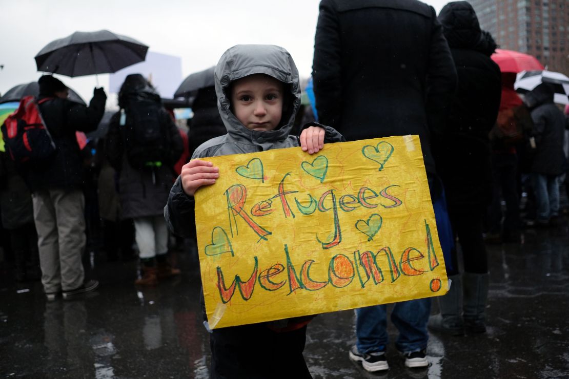 A boy holds a placard during a  Jewish rally for refugees in New York on February 12, 2017.