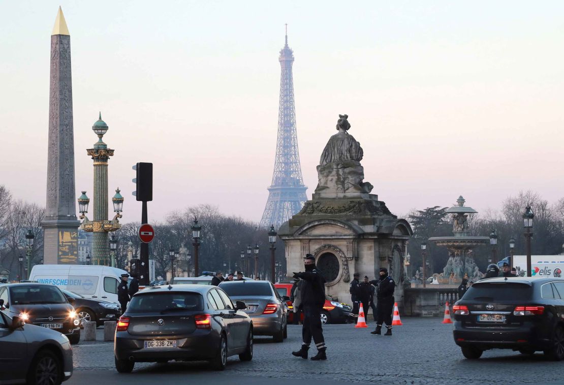 A policeman regulates traffic in Paris last month, where traffic restrictions are intended to curb emissions.