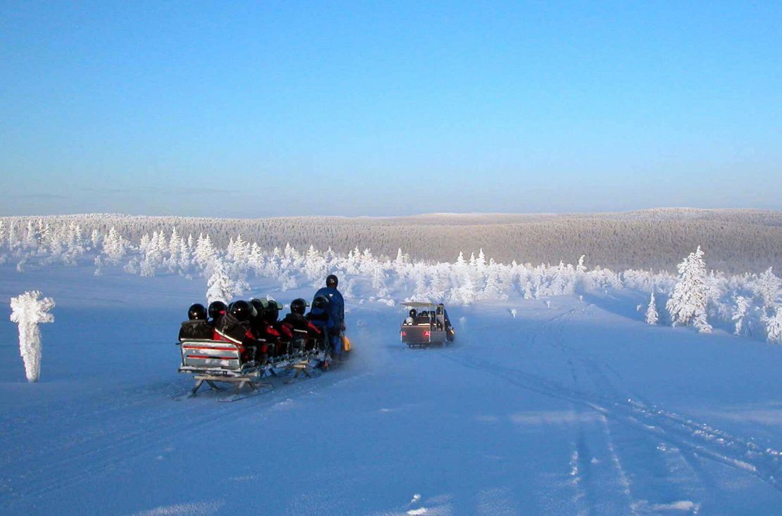 Tourists snowmobile in Lapland.