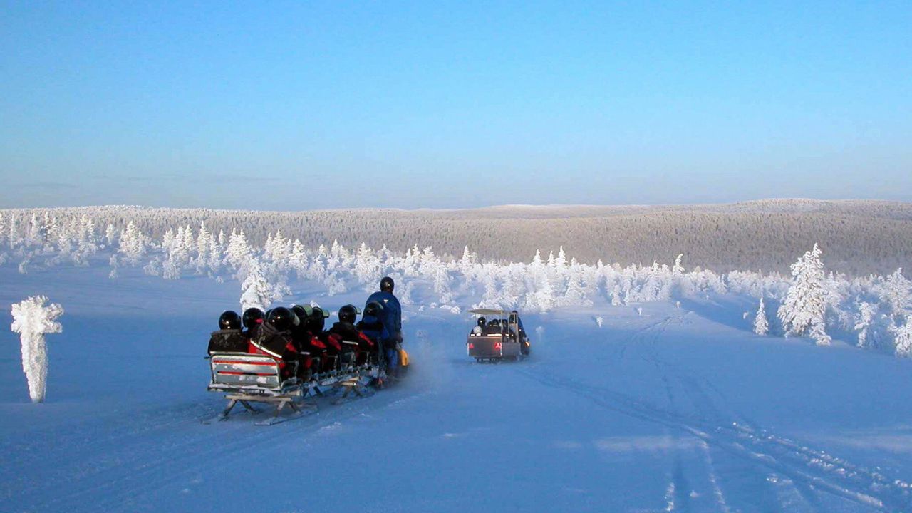 Tourists snowmobile in Lapland.