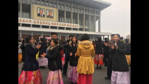 University students dance in front of the Pyongyang indoor stadium on February 16.