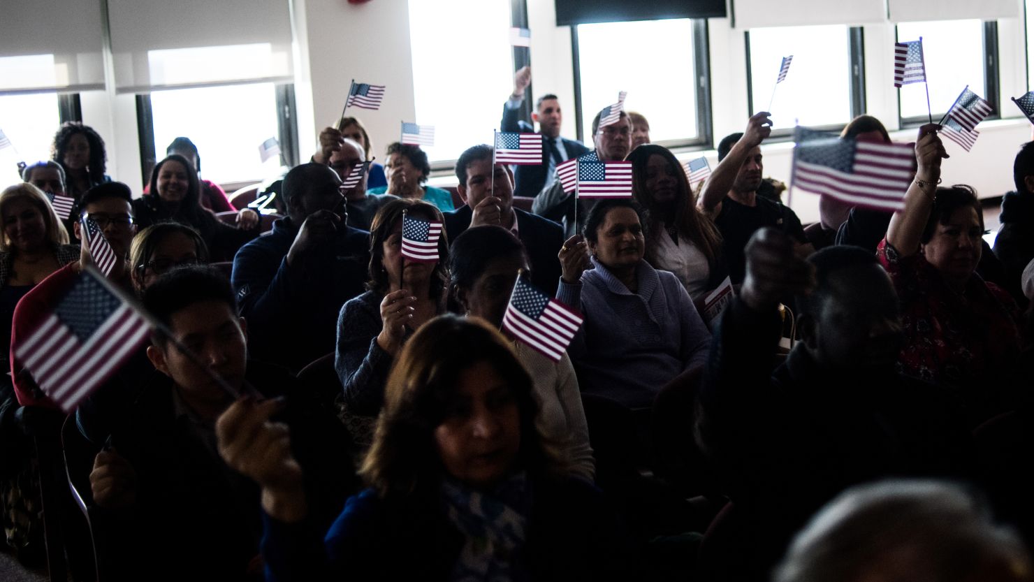 People wave their flags during the playing of "America the Beautiful" at a naturalization ceremony at the USCIS Peter Rodino Federal Building in Newark on Thursday, February 16.