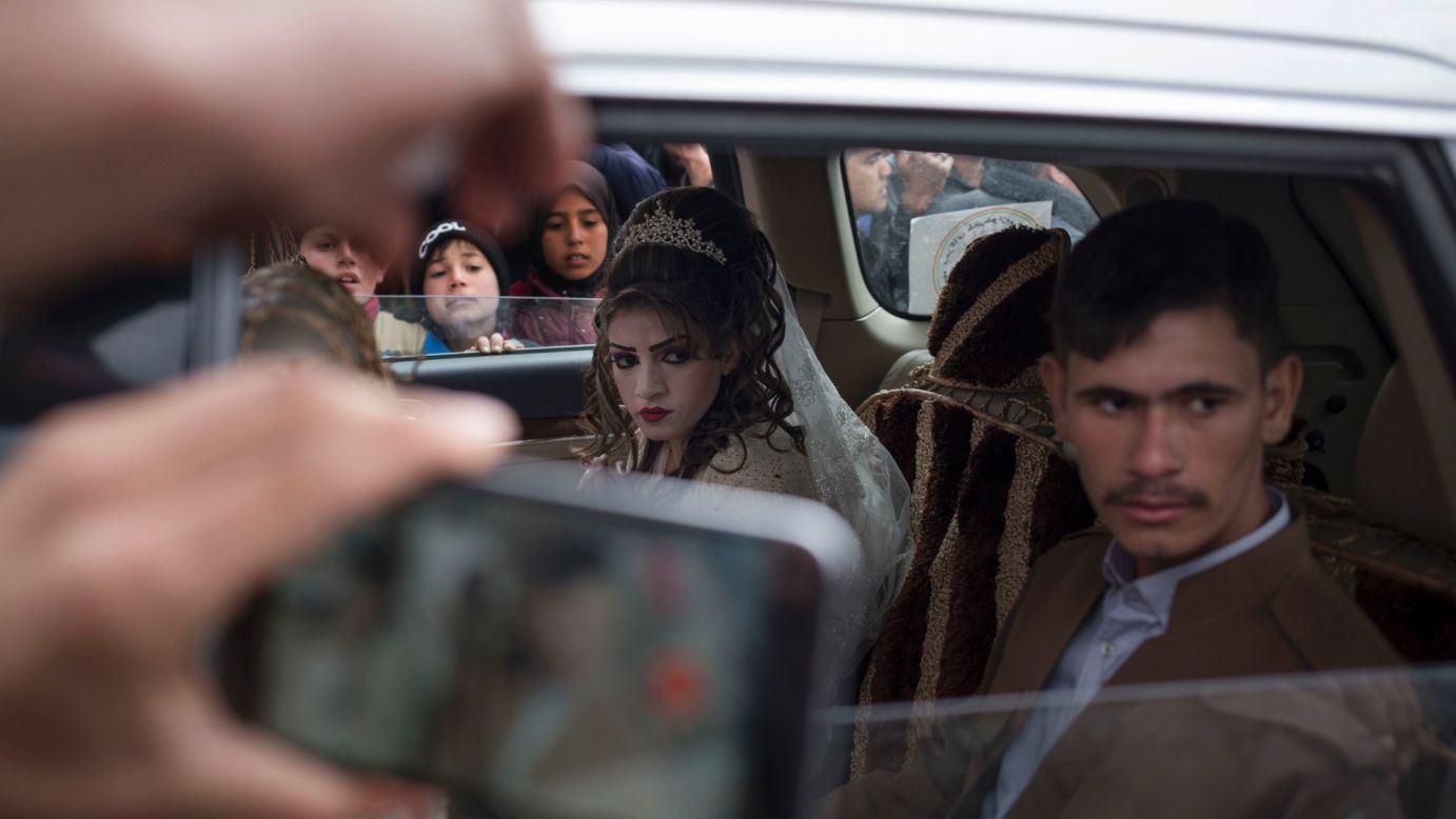 Hussein Zeino Danoon and Shahad Ahmed Abed sit inside a car after marrying in the Khazer refugee camp in Iraq on Thursday, February 16. The camp is east of Mosul, where an Iraqi-led coalition <a href="http://www.cnn.com/2016/10/17/world/gallery/mosul/index.html" target="_blank">has been fighting ISIS militants.</a>
