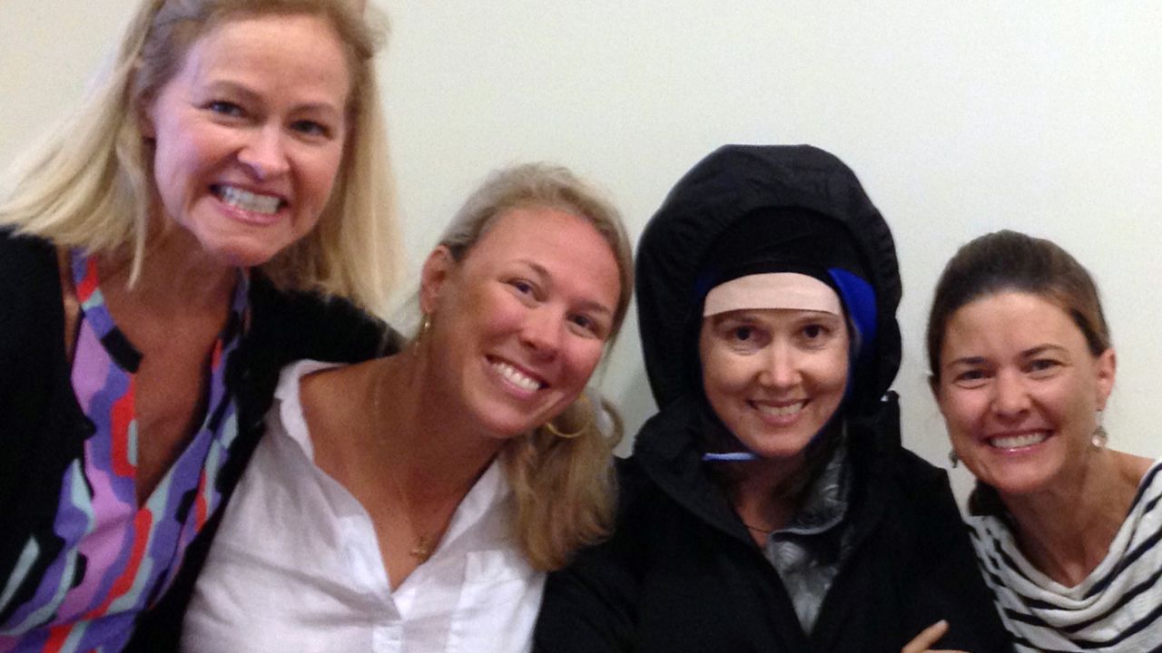 Emily Ferguson wears a cold cap during one of her treatments, surrounded by the friends who help her through it.