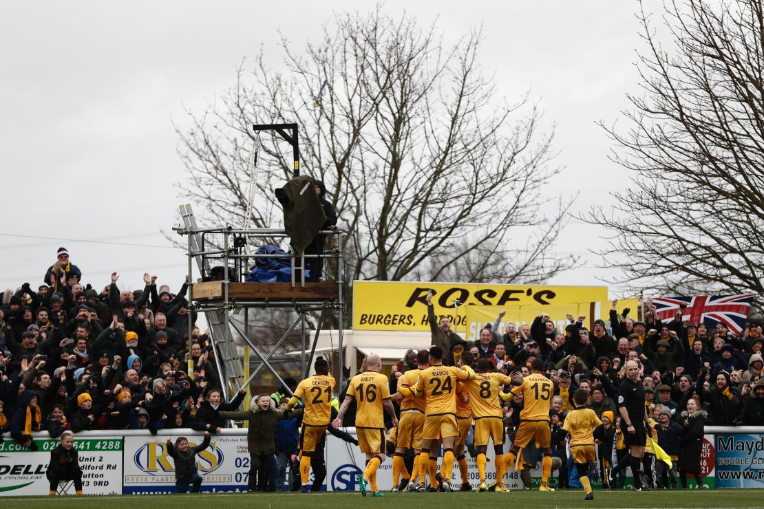 Sutton United players celebrate scoring the winning goal against Leeds United in the fourth round.