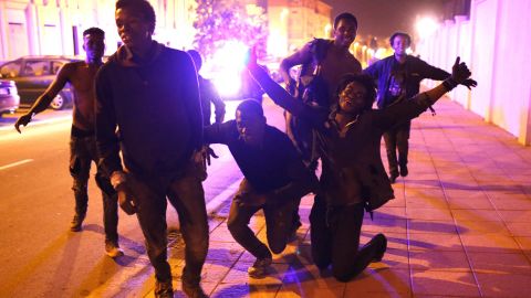 Migrants celebrate after storming the fence and entering the Spanish enclave of Ceuta.