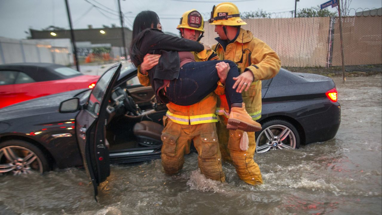 A firefighter carries a woman after floodwaters engulfed her car on a street in Los Angeles' Sun Valley neighborhood on February 17. 