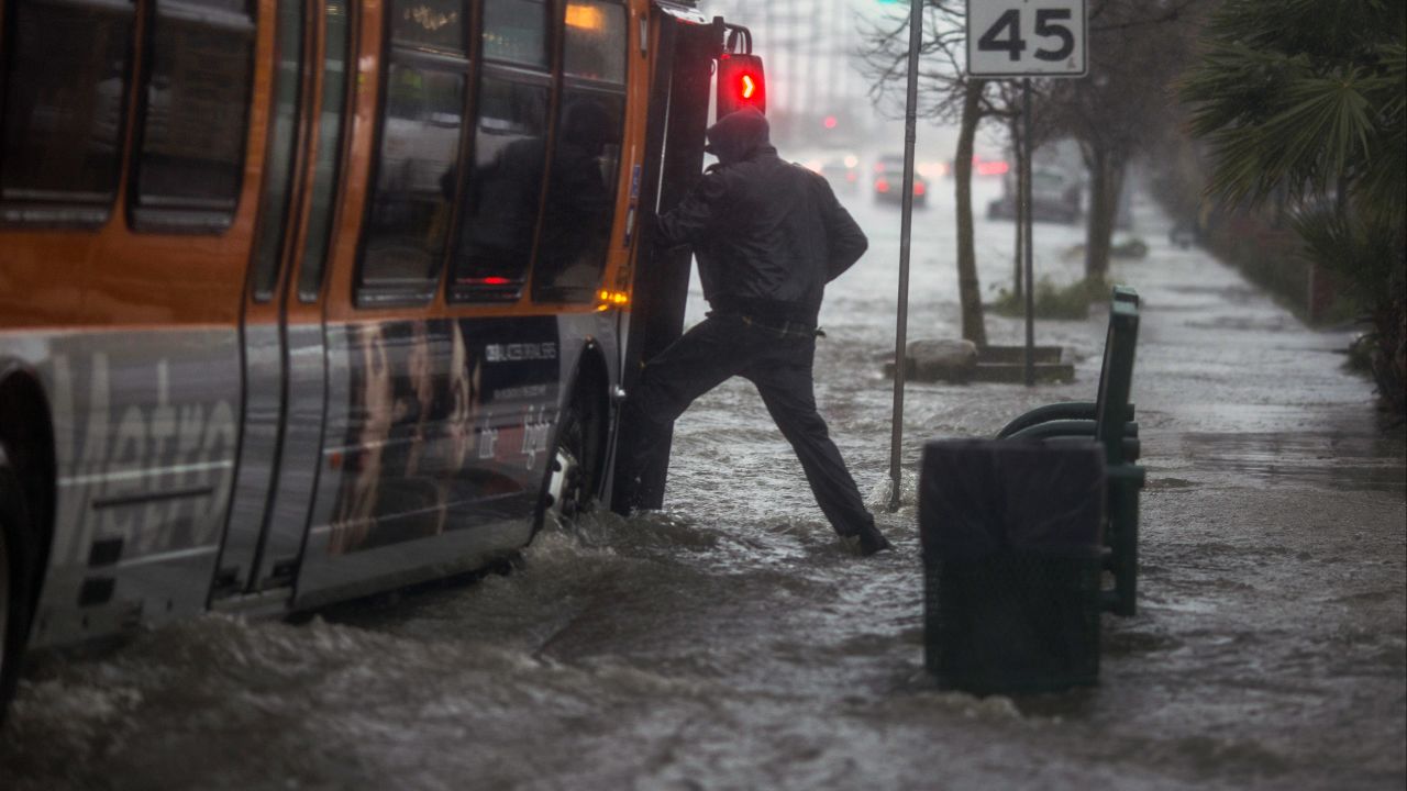 A man attempts to board a bus on a flooded street near the Sun Valley area of Los Angeles on February 17.