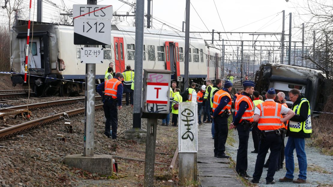 Police officers and officials stand next to a train after it derailed Saturday in Leuven, east of Brussels.