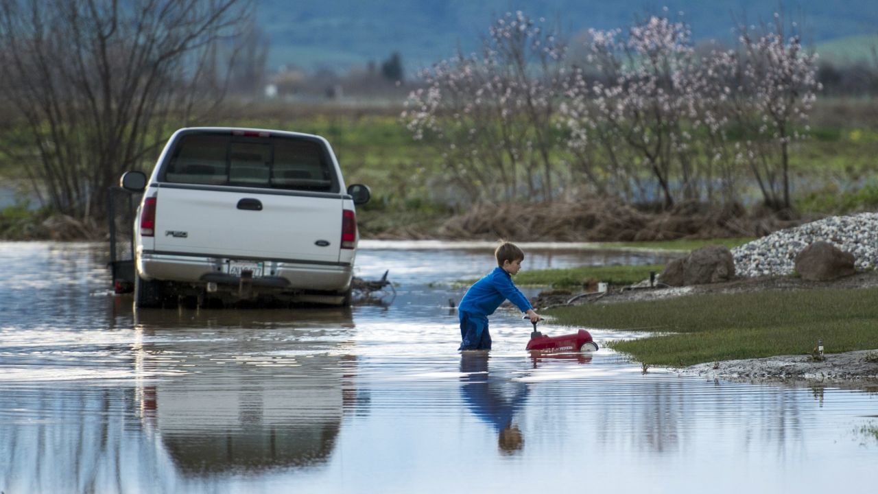 Barr Torrens plays in flooded neighborhood streets after a deluge of rain and runoff flooded much of Maxwell on February 18. 