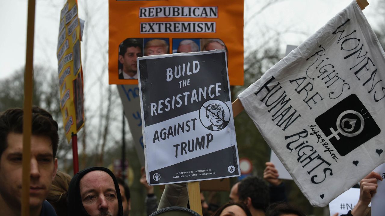 Protesters hold banners during a demonstration against Mike Pence's visit to Brussels on Monday.
